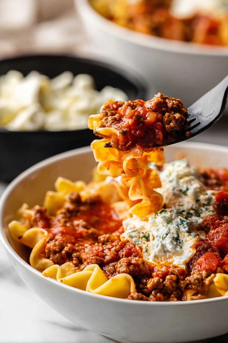 A white bowl is filled with layers of lasagna noodles, cooked ground meat in a rich red tomato sauce with visible chunks of tomato, and dollops of creamy ricotta cheese on top. The noodles are curly and golden yellow, sitting beneath and around the meat mixture. A black fork lifts a bite showing all layers mixed: noodles, meat sauce, and ricotta cheese. In the background, there is another white bowl with the same dish and a black bowl filled with white cheese curds. The scene is set on a white marbled surface. photo taken with an iphone --ar 2:3 --v 7
