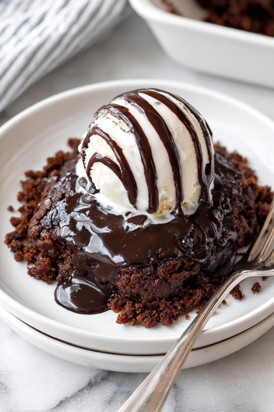 A white plate holds a chocolate dessert with three visible layers. The bottom layer is a dark brown crumbled cake, with a moist and slightly rough texture. On top is a thick layer of shiny dark chocolate sauce, pooling with a smooth, glossy finish. The third layer is a round scoop of creamy white vanilla ice cream sitting in the center, drizzled with stripes of dark chocolate sauce running down its sides. The plate rests on another identical white plate, all placed on a white marbled surface next to a metal-handled fork. Photo taken with an iphone --ar 2:3 --v 7